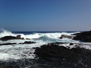 Surf crashing on the black lava rocks of Richardson's Beach in Hilo, Hawaii