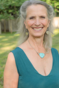 Headshot of Peggo Hodes in a green top with necklace.