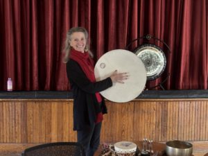 Peggo Hodes holding a drum for sound meditation